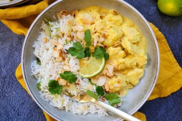photo culinaire d'un poulet korma healthy avec du riz basmati, des amandes effilées et de la coriandre.
