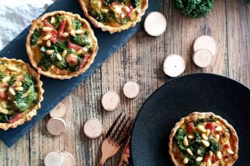 Petites quiches au chou gale et au bacon avec des pignons de pin dans une ambiance rustique et bois