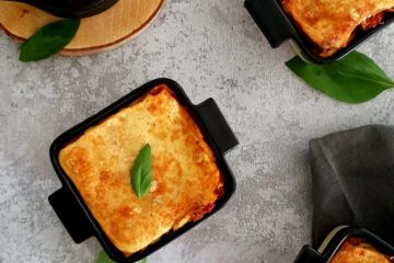 Petits plats de lasagnes veggie avec des lentilles et des feuilles de basilic frais