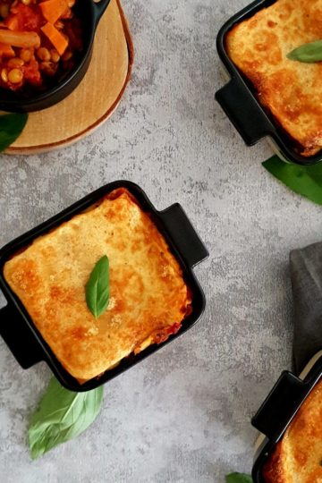 Petits plats de lasagnes veggie avec des lentilles et des feuilles de basilic frais
