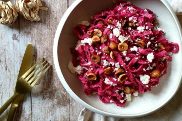 Assiette de tagliatelles à la crème de betterave avec de la feta et des noisettes concassées