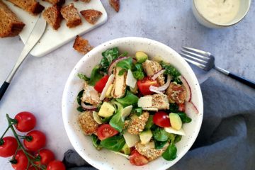 photo culinaire d'une salade caesar healthy et colorée à base de tofu pané, petites tomates, avocat et croûtons à l'ail