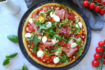 belle photo de pizza au chou-fleur avec des tomates, du jambon cru, de la mozzarella, de la roquette et du basilic