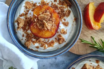 Photo culinaire de nectarines jaunes grillées sur un lit de yaourt au romarin et avec un crumble aux amandes