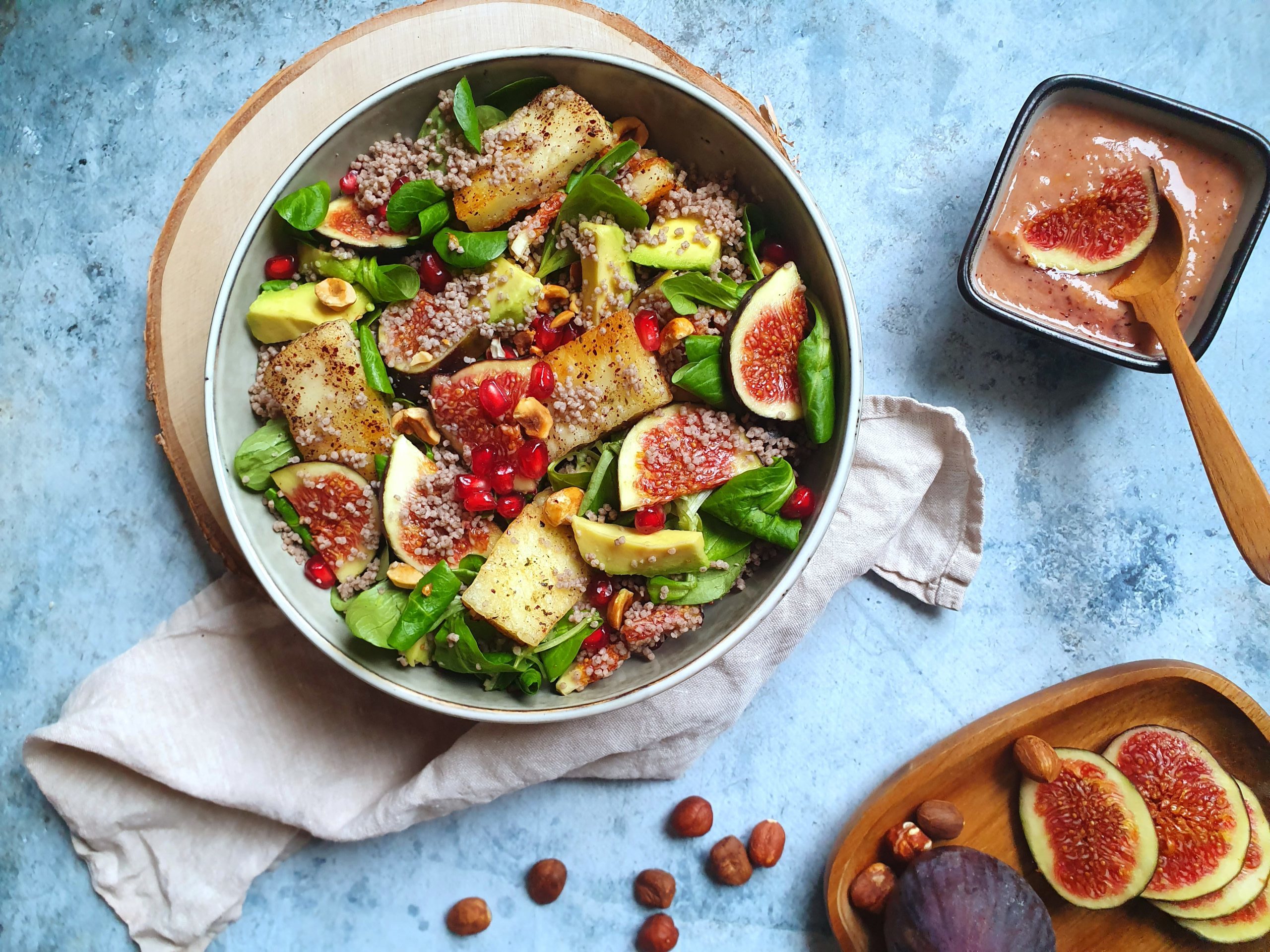 photo culinaire d'un taboulé de sarrasin aux figues, halloumi grillé aux noisettes et avocat avec un assaisonnement à la figue.