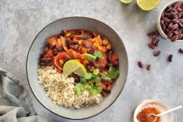 photo culinaire d'un chili sin carne à base de protéines de soja et servi avec du riz complet et de la coriandre fraîche