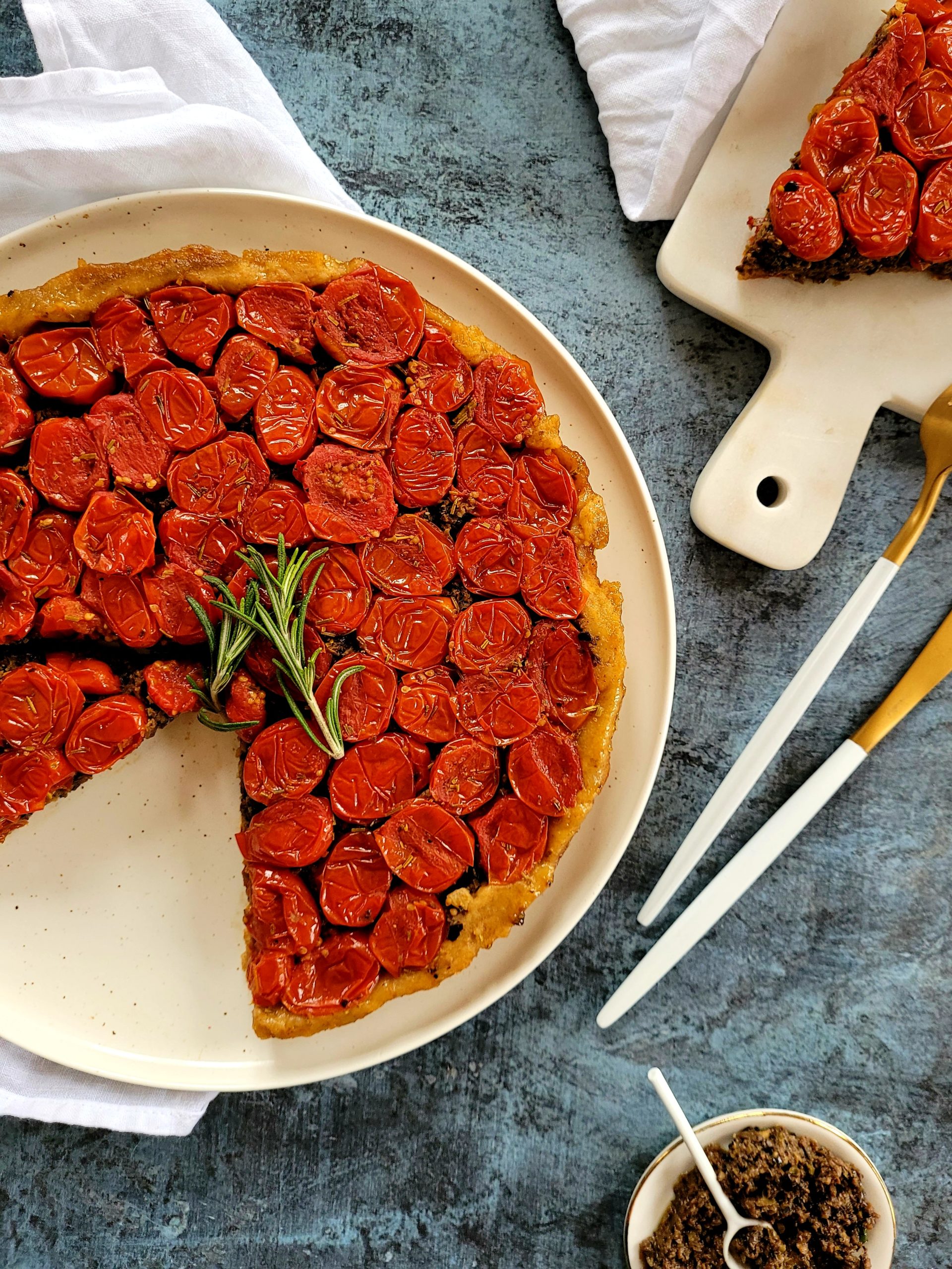 photo culinaire d'une tarte tatin aux tomates cerises et à la tapenade avec du romarin