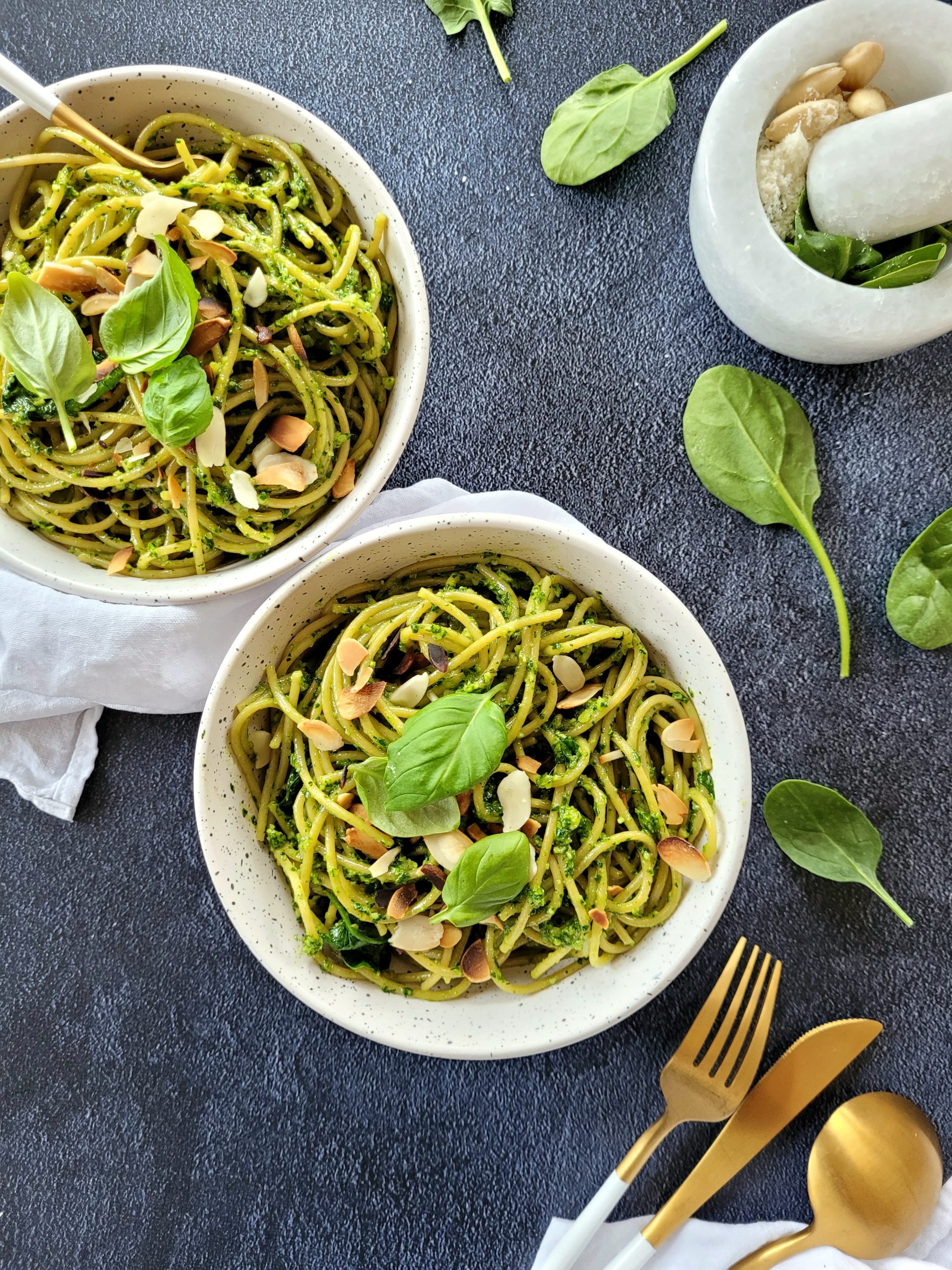 photo culinaire d'assiettes de pâtes au pesto d'épinards et amandes avec du basilic