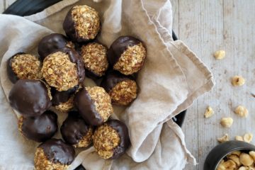 photo culinaire d'energy balls au praliné avec des noisettes et du chocolat noir fondu