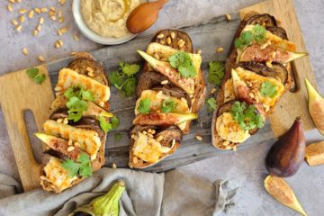 photo culinaire de tartines aux aubergines grillées et halloumi avec du houmous, des figues, des pignons de pin et de la coriandre