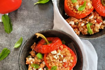 photo culinaire de poivrons farcis IG bas avec de l'orge mondé, des tomates, de la feta, de la menthe et du basilic