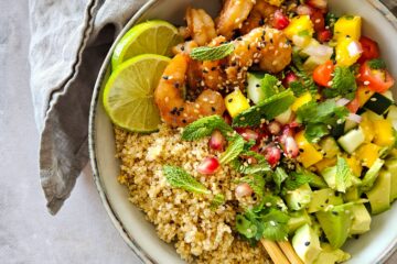 photo culinaire d'un bowl de crevettes exotiques avec une sauce à la mangue, du citron vert et une salsa tomate, mangue et concombre