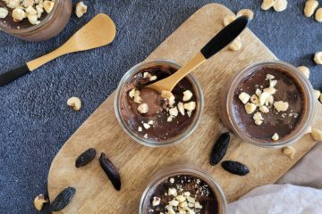 photo culinaire de petits pots de crème au chocolat et fèves tonka avec des noisettes concassées au-dessus