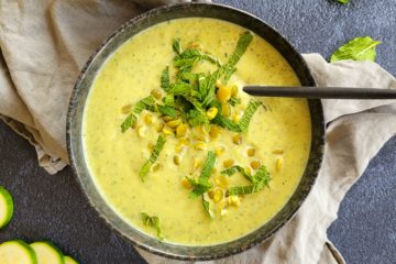 photo culinaire d'un velouté de courgettes et pois cassés à la menthe, la mise en avant d'aliments verts sur un fond sombre