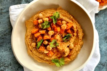 photo culinaire d'un houmous à la patate douce avec de coriandre fraîche et des graines de sésame