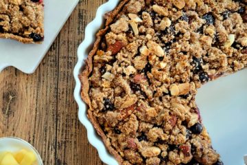 photo culinaire d'une tarte crumble aux pommes, myrtilles et amandes