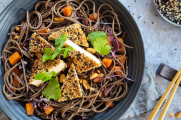 photo culinaire de tofu pané au sésame et nouilles soba aux légumes avec des carottes, du chou rouge et des cacahuètes concassées