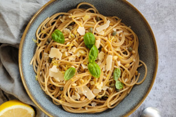photo culinaire de pâtes au citron, ail et câpres avec du basilic, des pignons de pin et du parmesan