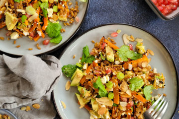 photo culinaire d'une salade de petit épeautre aux carottes rôties à l'orange avec de l'avocat, de la feta, des graines de grenade, des amandes effilées et de la coriandre