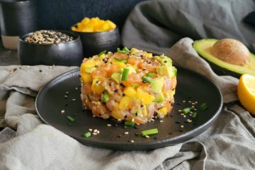 photo culinaire d'un tartare de saumon asiatique à l'avocat et la mangue avec de la ciboulette et du gingembre
