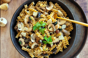 photo culinaire de pâtes aux champignons et à l'ail avec du persil et des olives noires
