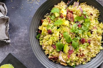 photo culinaire d'un taboulé de brocolis hivernal avec de l'avocat, des cranberries, des noix de pécan et de l'oignon rouge
