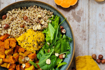 photo culinaire d'un bowl hivernal et houmous au curcuma avec des patates douces, des topinambours, du sarrasin et des noisettes