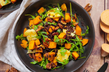 photo culinaire d'une salade de riz noir et patate douce avec du halloumi, de la roquette et des noix de pécan grillées au paprika