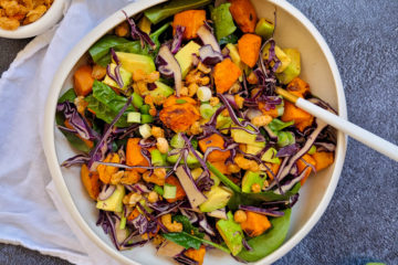 photo culinaire d'un bowl au chou rouge et patate douce avec de l'avocat, des épinards et des haricots blancs croustillants