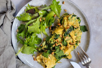 photo culinaire d'une omelette printanières avec des courgettes, des épinards et des pignons de pin