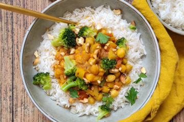 photo culinaire d'un curry de pois chiches servi avec du riz basmati, des brocolis et des noix de cajou torréfiées