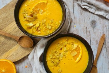 photo culinaire d'un velouté acidulé de carottes et lentilles corail avec du granola salé au curry et de l'orange