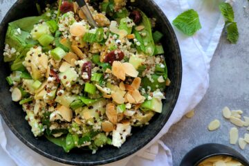 photo culinaire d'une salade de quinoa, avocat et feta avec des épinards, des cranberries et des amandes effilées