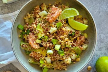 photo culinaire d'une salade de quinoa au saumon mariné avec de l'avocat, du concombre, des cacahuètes et une sauce sésame citron vert