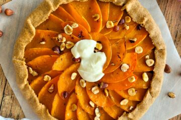 photo culinaire d'une tarte butternut rôti au miel et au thym sur un lit d'oignon et avec des noisettes et de la mozzarella