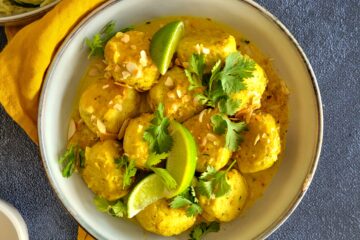 photo culinaire de boulettes de poisson coco curry avec une sauce à base de lait de coco, d'oignons, de citron vert et de coriandre fraîche