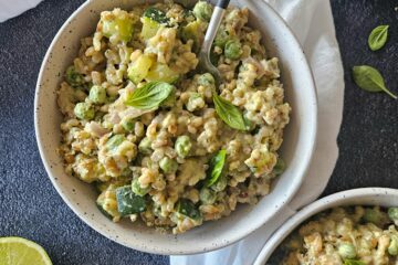 photo culinaire d'un risotto d'orge aux courgettes, petits pois et basilic avec du citron vert et du parmesan râpé