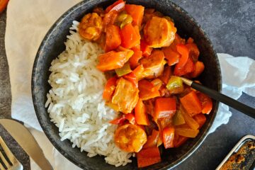 photo culinaire d'un rougail saucisses aux poivrons servi avec du riz