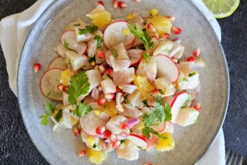 photo culinaire d'un ceviche aux agrumes et radis réalisé avec du poisson blanc, des graines de grenade, des radis, de l'orange, du citron vert et de la coriandre.