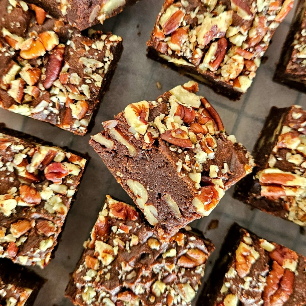 photo culinaire d'un focus sur une part de brownie à la courge avec des noix de pécan
