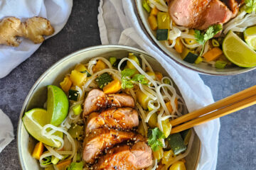 photo culinaire de tranches de filet mignon de porc laqué à l'asiatique avec des nouilles de riz et des légumes