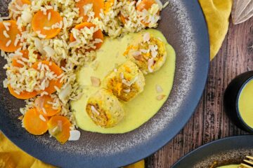 photo culinaire de boulettes de saumon à l'orange avec une sauce crémeuse à l'orange, du riz complet, des carottes et des amandes effilées