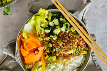 photo culinaire d'un lap veggie au tofu croustillant avec des lamelles de carottes, de la salade, des concombres, du riz basmati et des noix de cajou