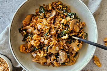 photo culinaire d'un risotto de petit épeautre aux champignons avec des épinards, des noix et du parmesan