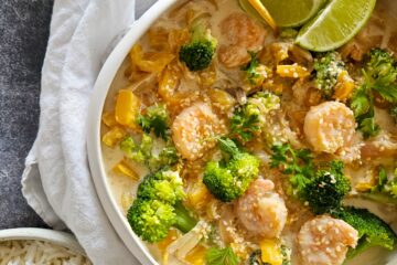 photo culinaire d'un mijoté de crevettes au tahini et lait de coco avec des poivrons, des brocolis et du citron vert, servi avec du riz basmati