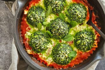 photo culinaire de boulettes d'épinards style storzapretti avec de la ricotta, de la menthe et une sauce tomate aux oignons caramélisés