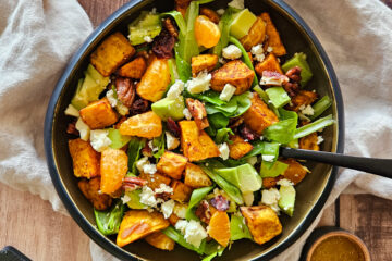 photo culinaire d'une salade de patate douce aux agrumes avec des avocats, des morceaux de mandarine, de la feta et des noix de pécan