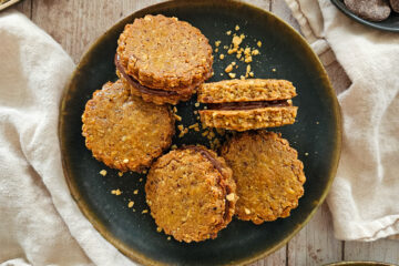 photo culinaire de biscuits fourrés chocolat-noisette avec des noisettes, de la poudre de noisettes et du chocolat noir