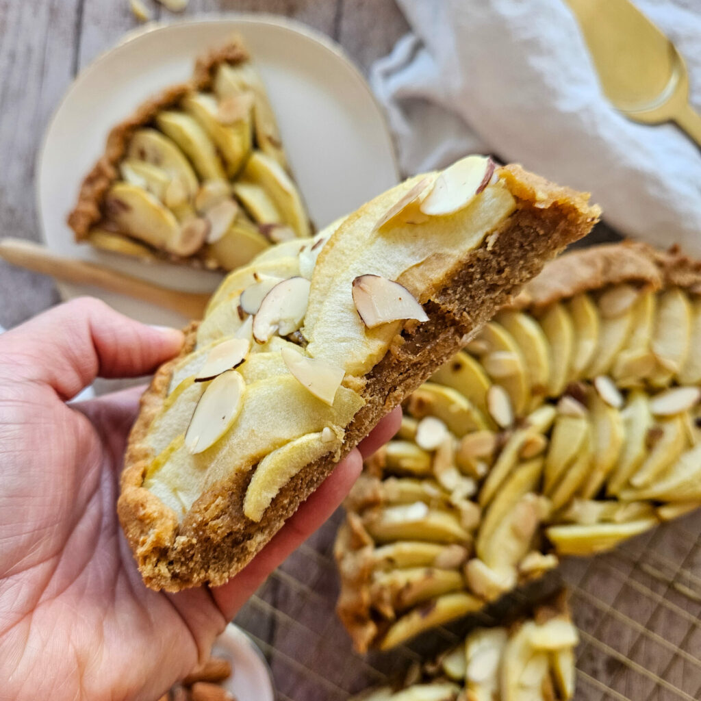 photo culinaire d'une part de tarte aux pommes et amandes façon frangipane simplifiée avec des amandes effilées