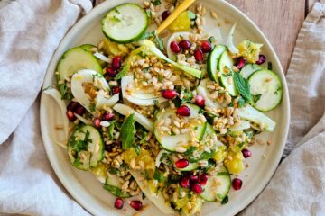 photo culinaire d'une salade d'orge fruitée au fenouil avec des concombres, des segments d'orange, de la menthe et de la coriandre